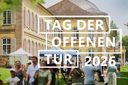 Foto: Schloss Hohenheim mit Personen im Vordergrund. Ein großes Banner mit der Aufschrift 'Tag der offenen Tür 2026' ist sichtbar. Menschen bewegen sich auf dem Gelände, einige Zelte sind aufgestellt.
