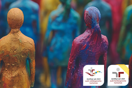 Foto: Bunte Figuren aus verschiedenen Materialien stehen dicht beieinander. Unten rechts sind zwei Zertifikate sichtbar: 'Zertifikat seit 2023 audit vielfaltsgerechte hochschule' und 'Zertifikat seit 2004 audit familiengerechte hochschule'.