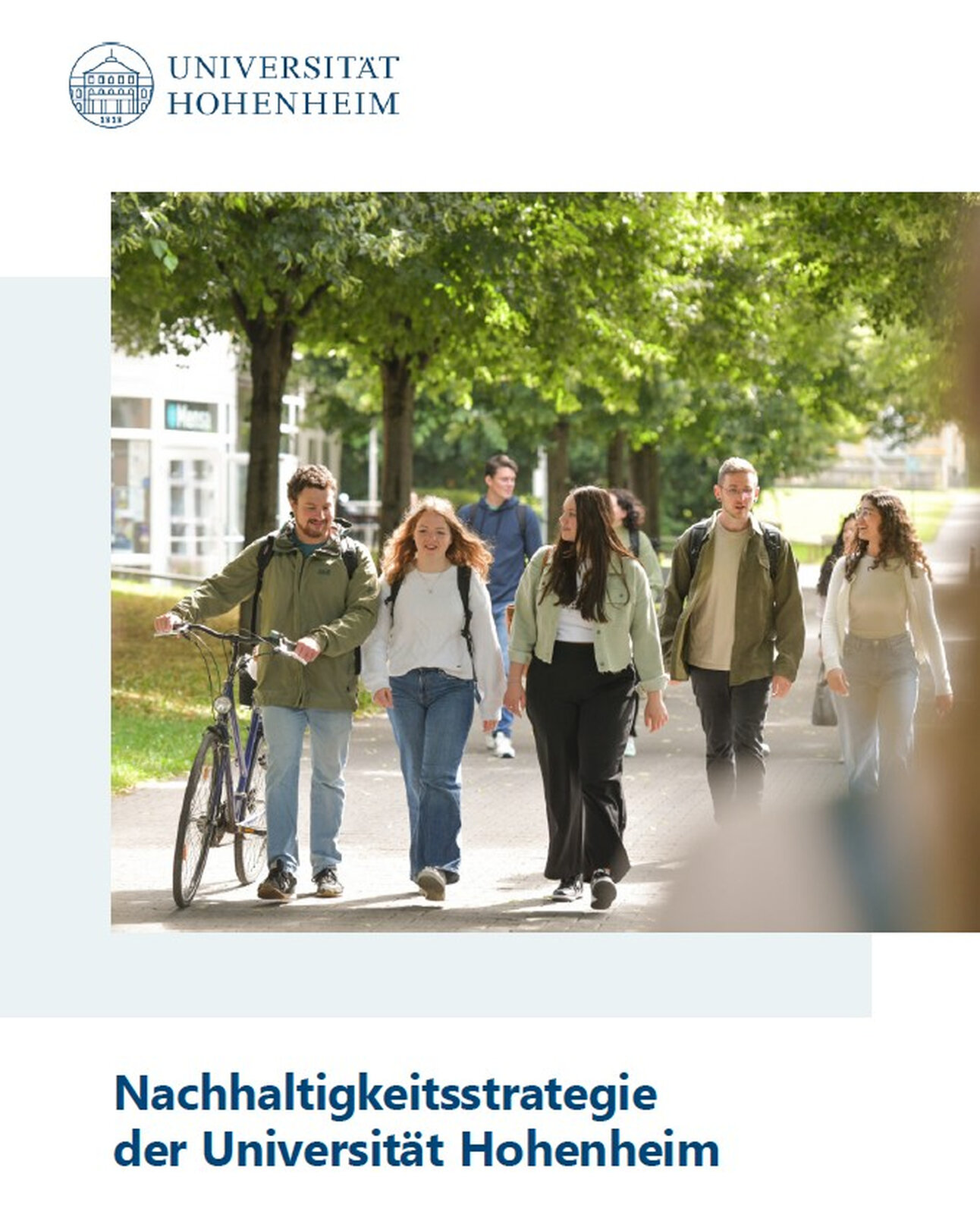Foto: Eine Gruppe von Personen geht auf einem von Bäumen gesäumten Weg auf dem Campus der Universität Hohenheim. Oben ist das Logo der Universität und der Text 'Nachhaltigkeitsstrategie der Universität Hohenheim, Stand: Dezember 2025' sichtbar.
